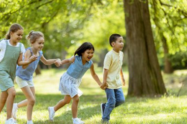 Group of cute asian and caucasian kids having fun in the park