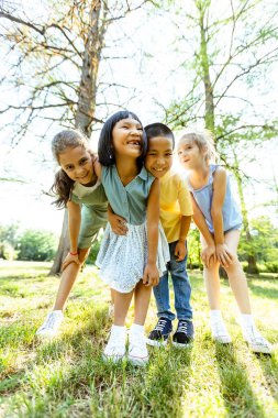 Group of cute asian and caucasian kids having fun in the park