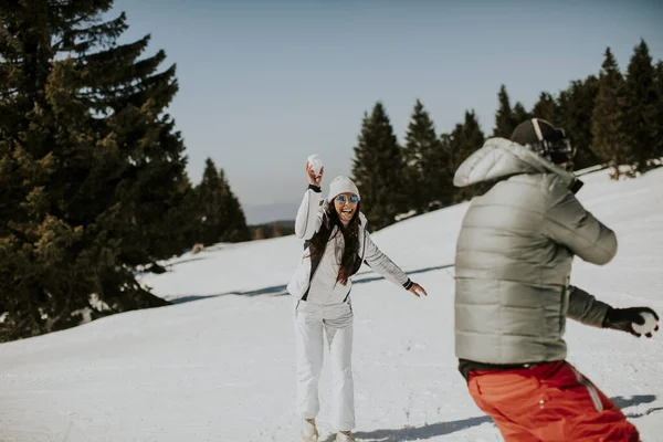 在阳光灿烂的山上 一对年轻夫妇正在打雪仗 — 图库照片