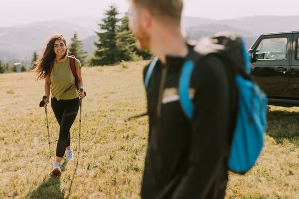 Gülümseyen Genç Çift Yeşil Tepelerde Sırt Çantalarıyla Yürümeye Başlıyor — Stok fotoğraf