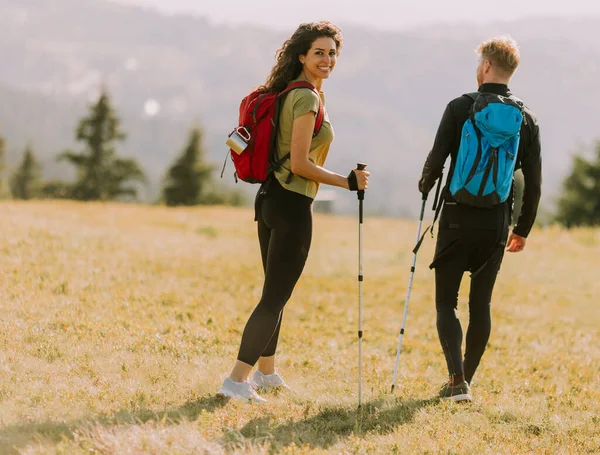 Lächelndes Junges Paar Läuft Mit Rucksack Über Grüne Hügel — Stockfoto