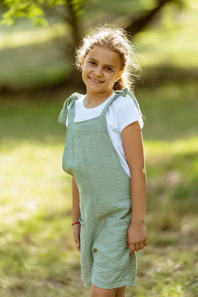 Χαριτωμένο Κοριτσάκι Στέκεται Στο Πάρκο Μια Ηλιόλουστη Μέρα — Φωτογραφία Αρχείου