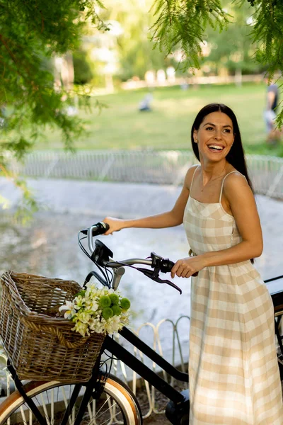 Elektrikli Bisiklet Sepetinde Çiçekleri Olan Güzel Genç Bir Kadın — Stok fotoğraf