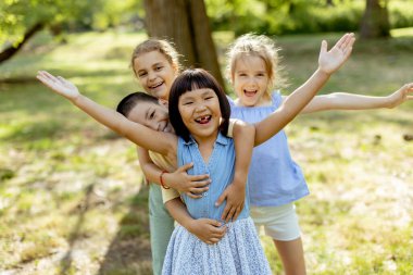 Group of cute asian and caucasian kids having fun in the park