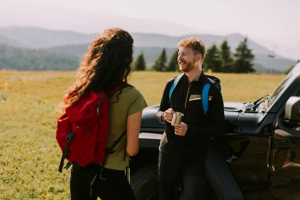 Smiling Young Couple Preparing Hiking Adventure Backpacks Terrain Vehicle — Stok fotoğraf