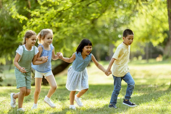 Bir grup yakışıklı Asyalı ve beyaz çocuk parkta eğleniyor.