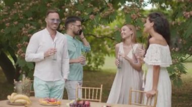 Taze limonatayla tezahürat yapan ve bahçede meyve yiyen bir grup mutlu genç.