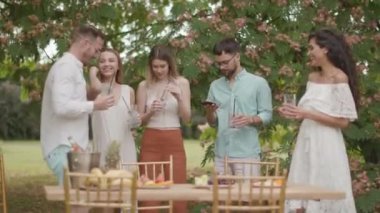 Taze limonatayla tezahürat yapan ve bahçede meyve yiyen bir grup mutlu genç.