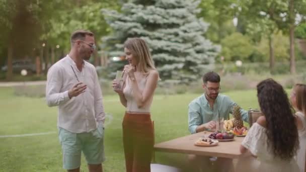 園内では 新鮮なレモネードとフルーツを食べながら応援する幸せな若者たちのグループ — ストック動画
