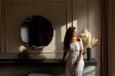 Young curly hair woman standing in the room