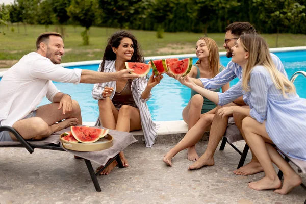 Group Young People Sitting Swimming Pool Eating Watermelon House Backyard — ストック写真