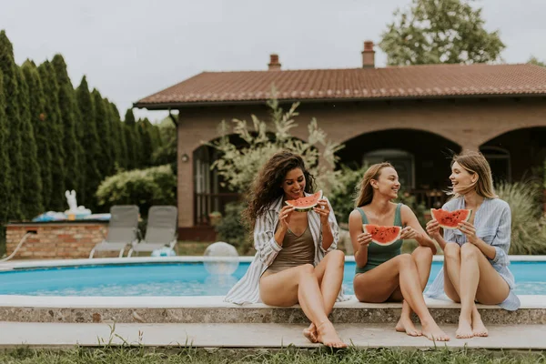 Three Cute Young Women Sitting Swimming Pool Eating Watermelon House — Stock fotografie