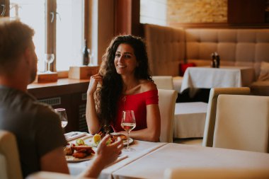 Handsome young couple having lunch with white wine in the restaurant