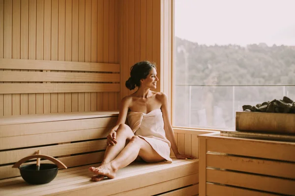 Attractive young woman relaxing in the sauna