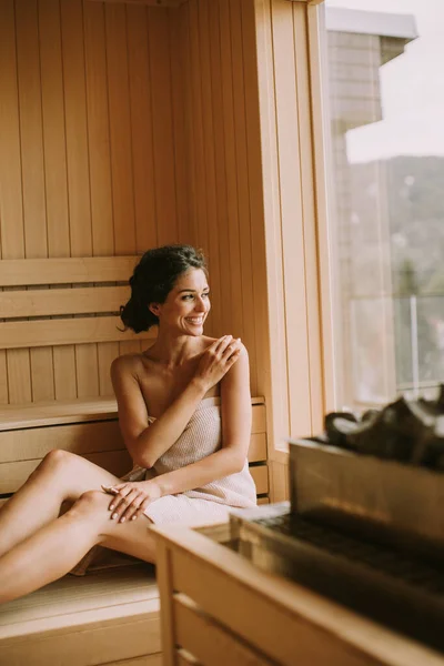 Attractive young woman relaxing in the sauna