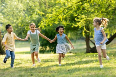 Group of cute asian and caucasian kids having fun in the park