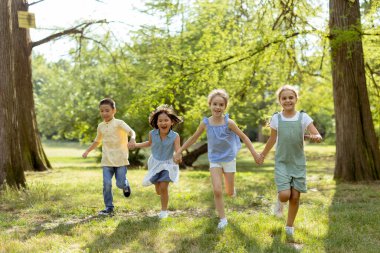 Group of cute asian and caucasian kids having fun in the park