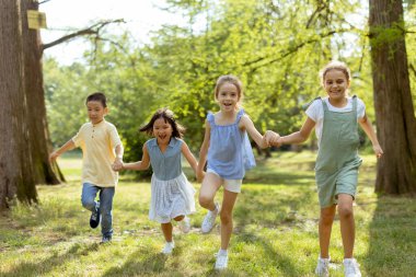 Group of cute asian and caucasian kids having fun in the park