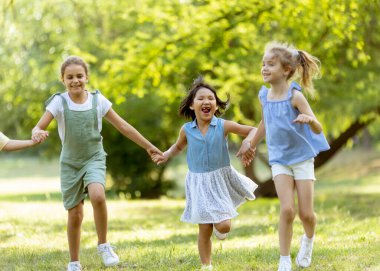 Group of cute asian and caucasian girls having fun in the park
