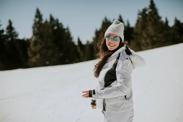 一个阳光灿烂的日子站在滑雪道上的年轻女子 — 图库照片