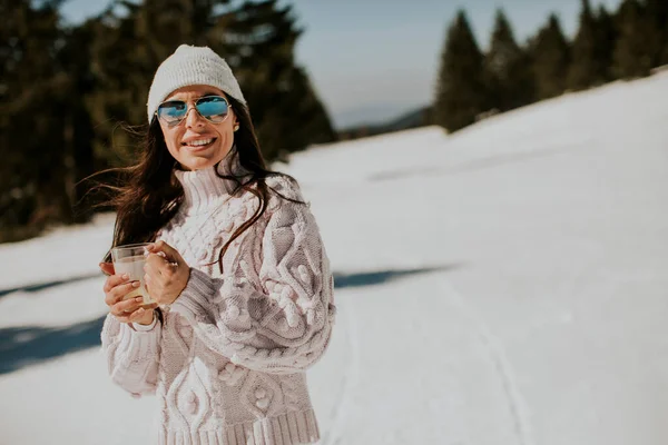 在一个阳光明媚的冬日 年轻女子在高山滑雪道上喝柠檬水 — 图库照片