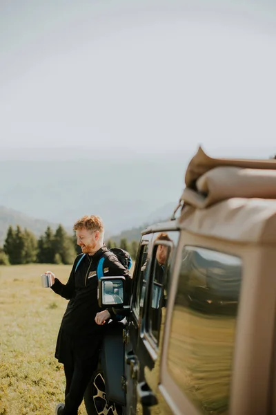 Handsome Young Man Relaxing Drinking Coffee Terrain Vehicle Hood Countryside — Stock fotografie