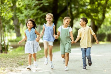 Group of cute asian and caucasian kids having fun in the park