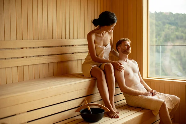 Handsome young couple relaxing in the sauna