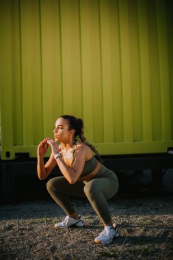 Dışarıda atlama egzersizi yapan genç ve çekici bir kadına bakın.