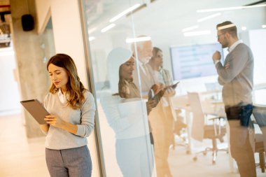 Ofisinde dijital tableti olan genç ve güzel bir kadın.