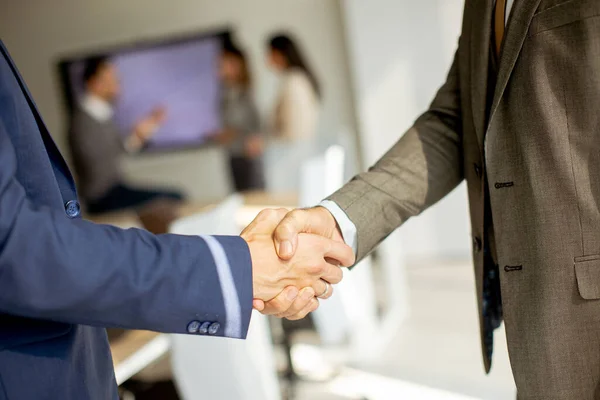 事務所の若い同僚と握手する高級ビジネスマン — ストック写真