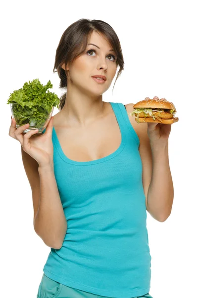 Woman making decision between healthy salad and fast food — Stock Photo, Image