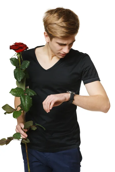Man holding red rose and looking at his wirstwatch — Stock Photo, Image