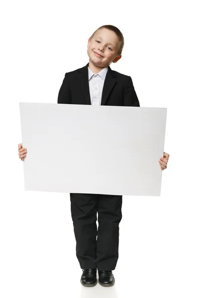 Full length of a schoolboy holding blank banner — Stockfoto