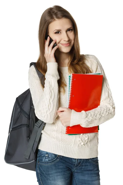 Студент с рюкзаком и книгами разговаривает по мобильному телефону — стоковое фото