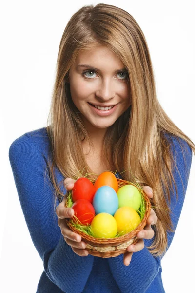 Donna sorridente che tiene il cesto con le uova di Pasqua — Foto Stock