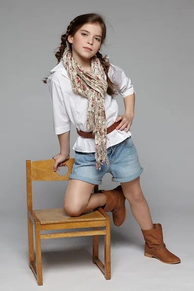 Girl standing on the wooden chair — Stock Photo, Image