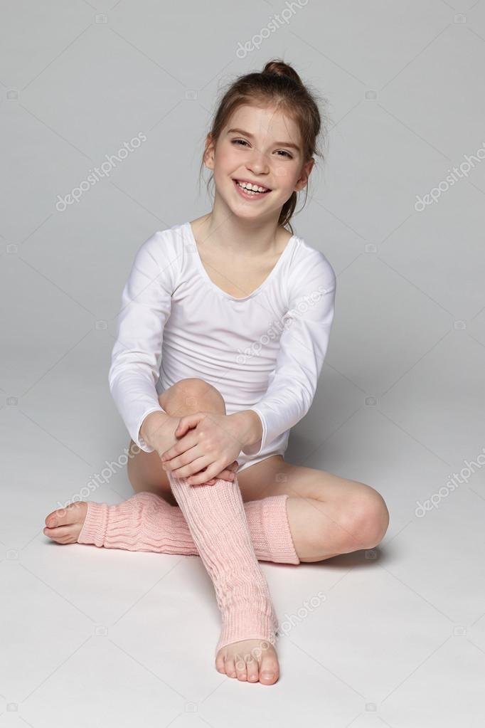 Little girl wearing sport clothing sitting on the floor Stock Photo by  ©pavel_kolotenko 23747857