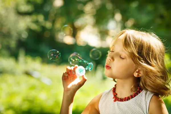 Girl blowing soap bubbles — Stock Photo, Image
