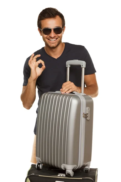 Young male with silver travel suitcase, showing OK sign — Stock Photo, Image