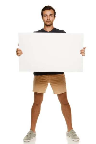 Young man in summer clothing with blank banner — Stock Photo, Image