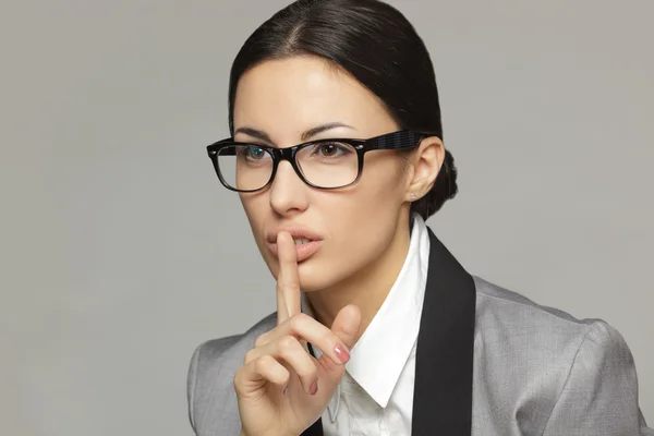 Geschäftsfrau mit dem Finger auf den Lippen — Stockfoto