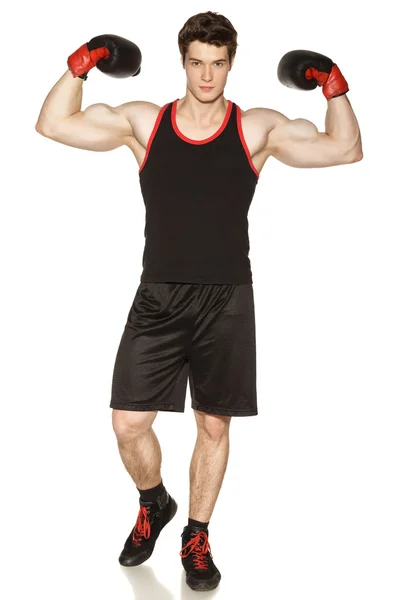 Мужчина в боксёрских перчатках показывает свои мускулы — стоковое фото