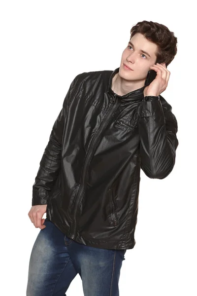 Man wearing black jacket and jeans talking on cellphone — Stock Photo, Image