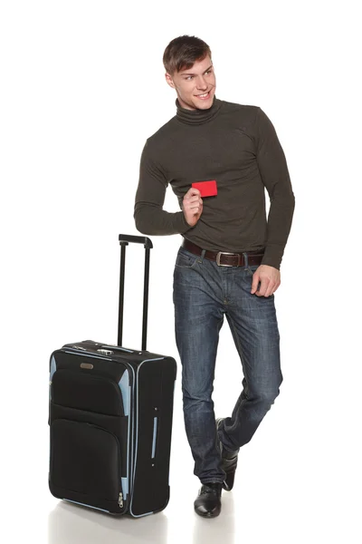 Мужчина в полной длине стоит с чемоданом, показывая пустую кредитную карту — стоковое фото