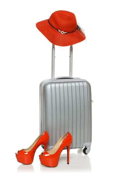 Срібна валіза з червоним солом'яним капелюхом та взуттям на високих каблуках — стокове фото