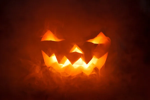 Scary Halloween Pumpkin looking through the smoke. — Stock Photo, Image