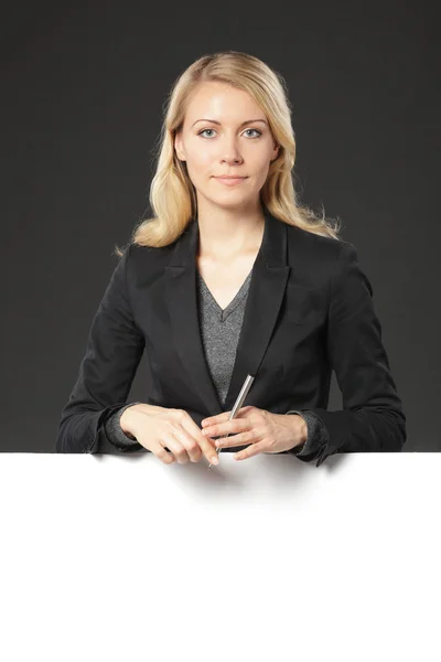 Businesswoman standing behind a blank banner — Φωτογραφία Αρχείου