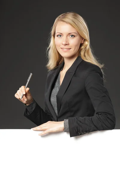 Businesswoman standing behind and leaning on a whiteboard — Stock Photo, Image