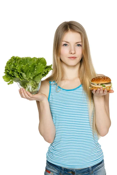 Vrouw overgaat tussen gezonde salade en fast food — Stockfoto